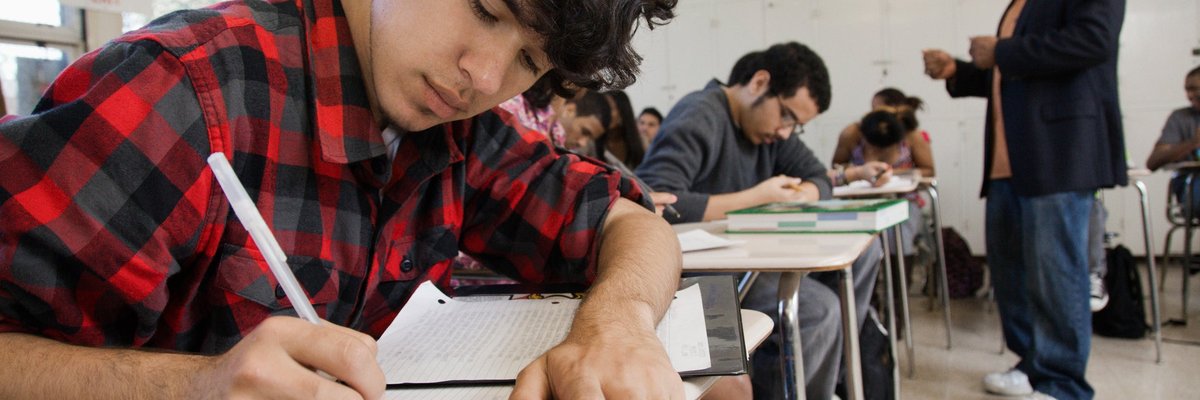 Male teacher interacts with classroom of high school students.