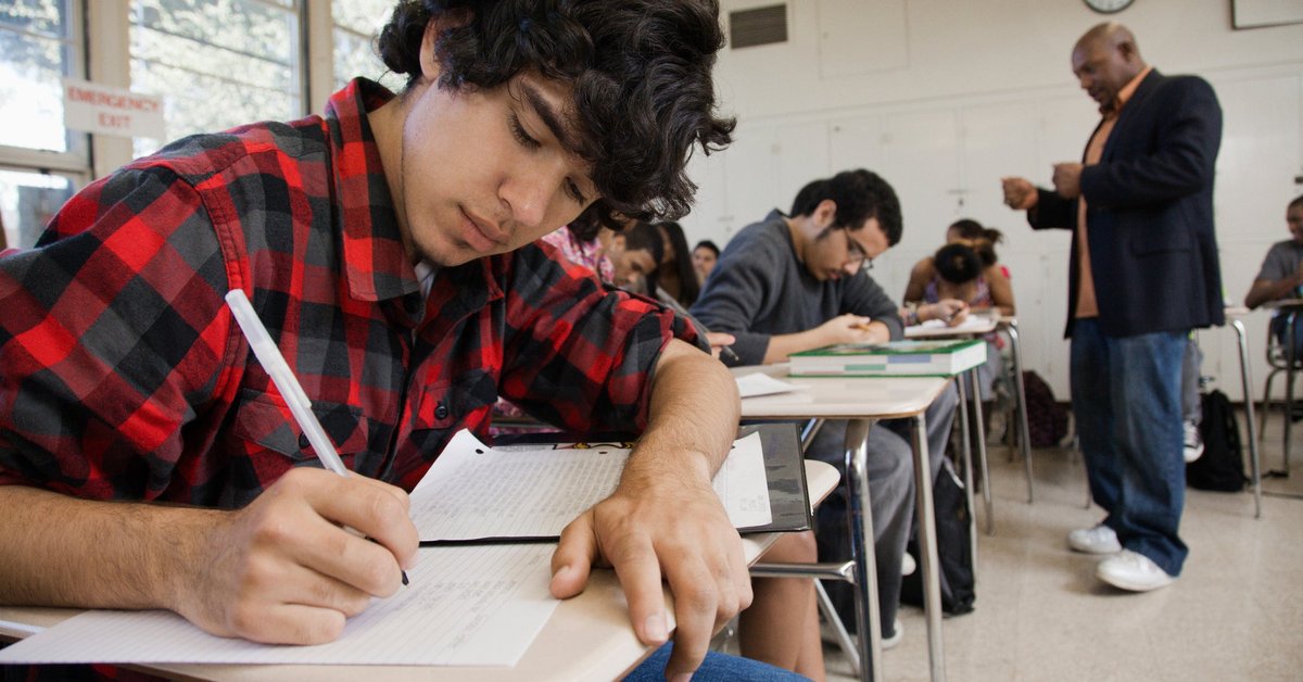 Male teacher interacts with classroom of high school students.