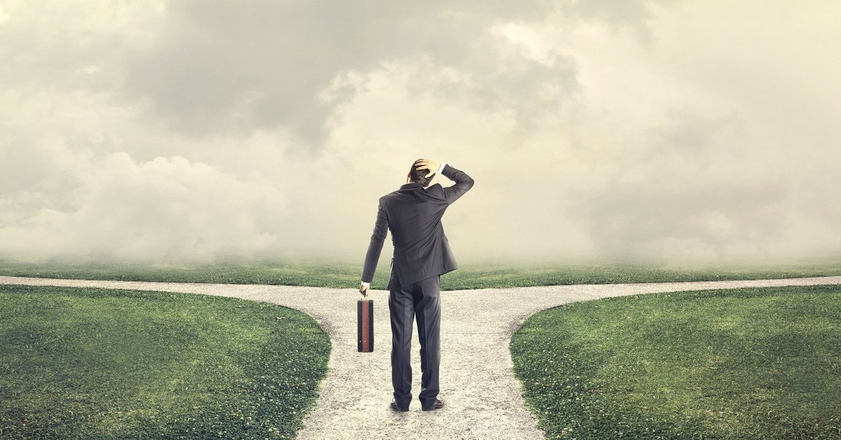 Man looking at two diverging paths and scratching his head