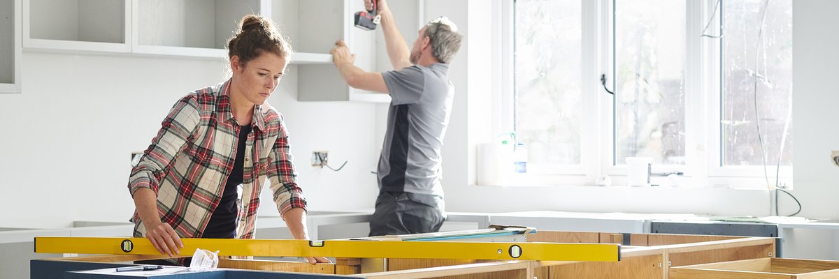 Man and woman working on a kitchen remodel.