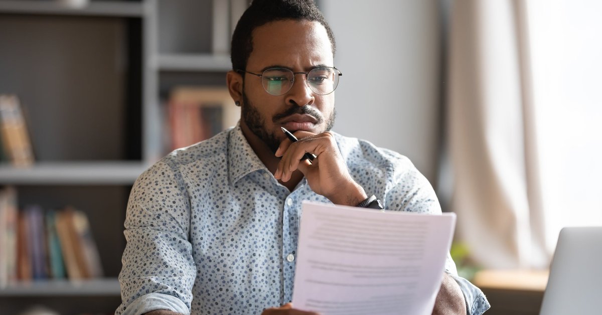Man looking at documents with unsure expression.