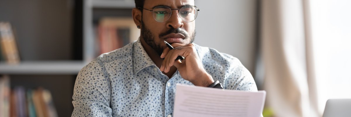 Man looking at documents with unsure expression.