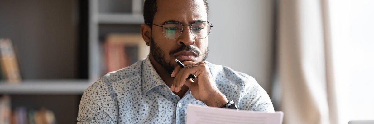 Man looking at documents with unsure expression.