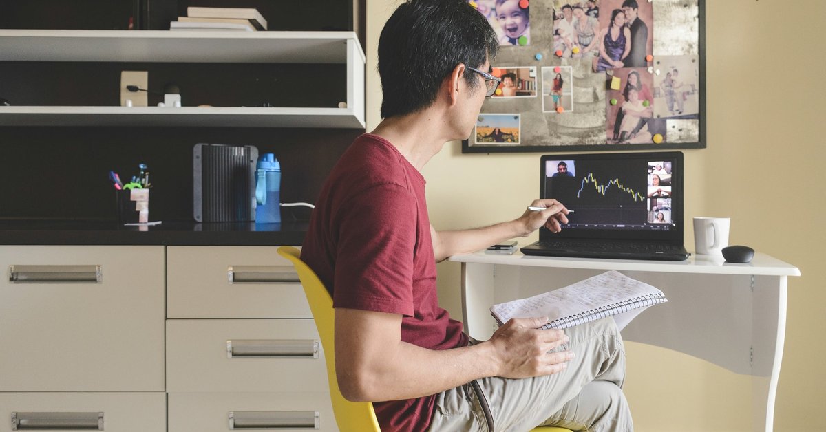 Man pointing to downward trending data on his laptop while on a video conference.