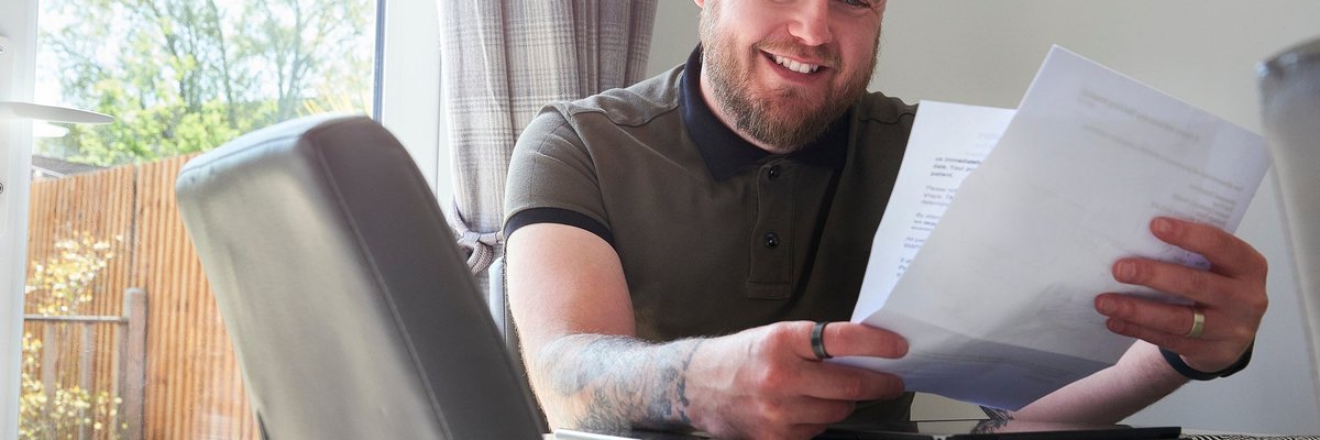 Man smiling reading a letter.