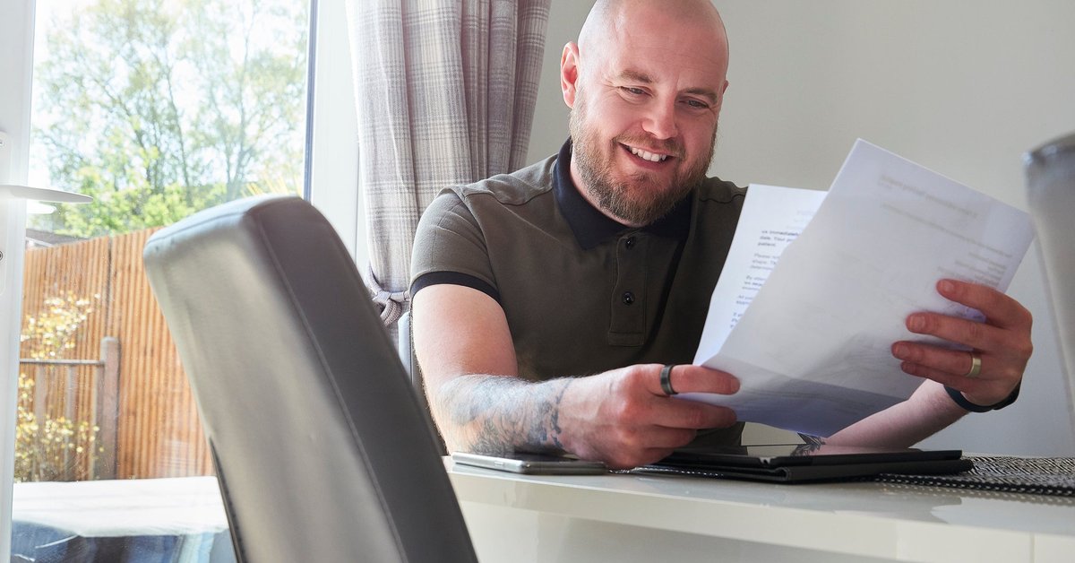Man smiling reading a letter.