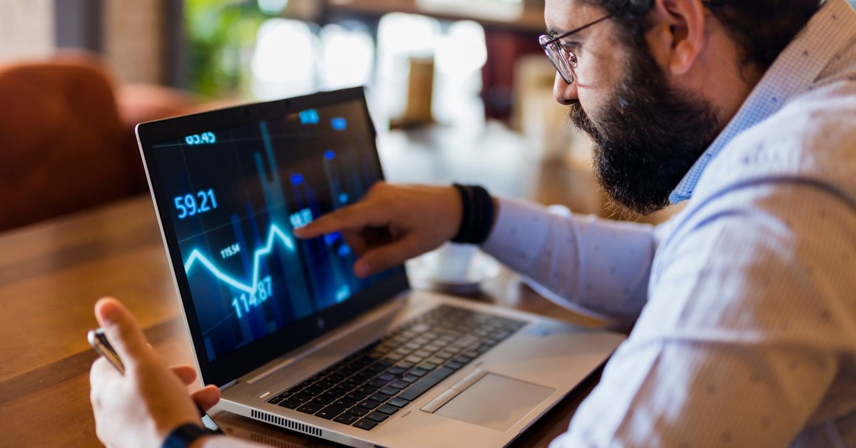 Man tracking downward performance of asset on a laptop.