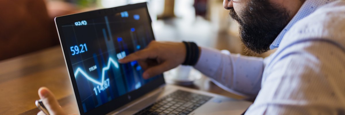 Man tracking downward performance of asset on a laptop.