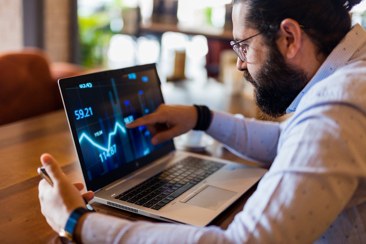 Man tracking downward performance of asset on a laptop.