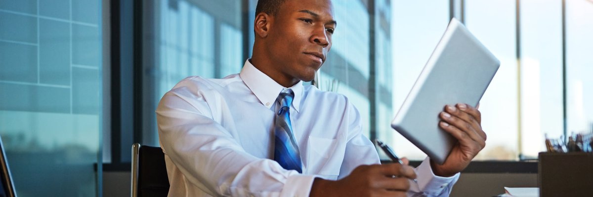A man at the office looks at his tablet