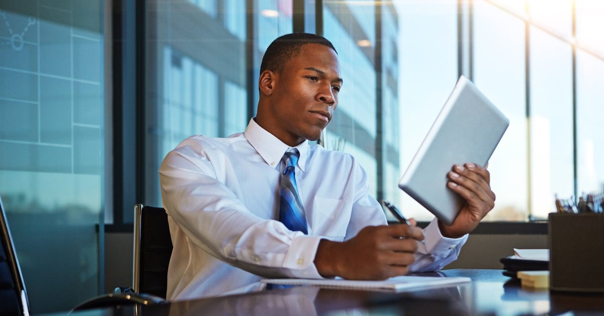 A man at the office looks at his tablet