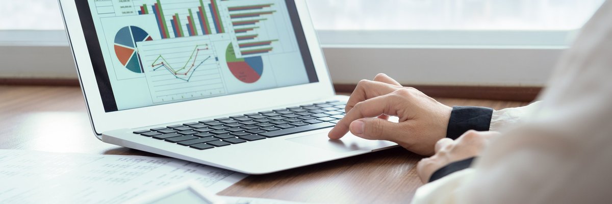 Man analyzing laptop that's displaying charts and graphs.