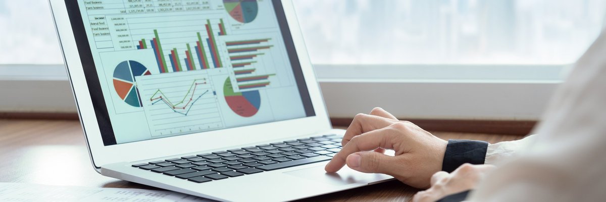 Man analyzing laptop that's displaying charts and graphs.