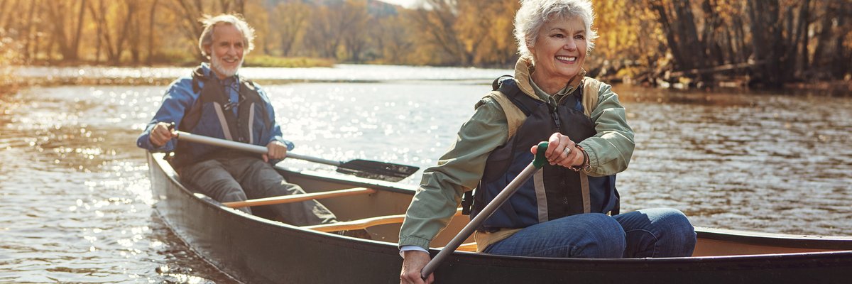 Mature couple rowing together in a canoe.