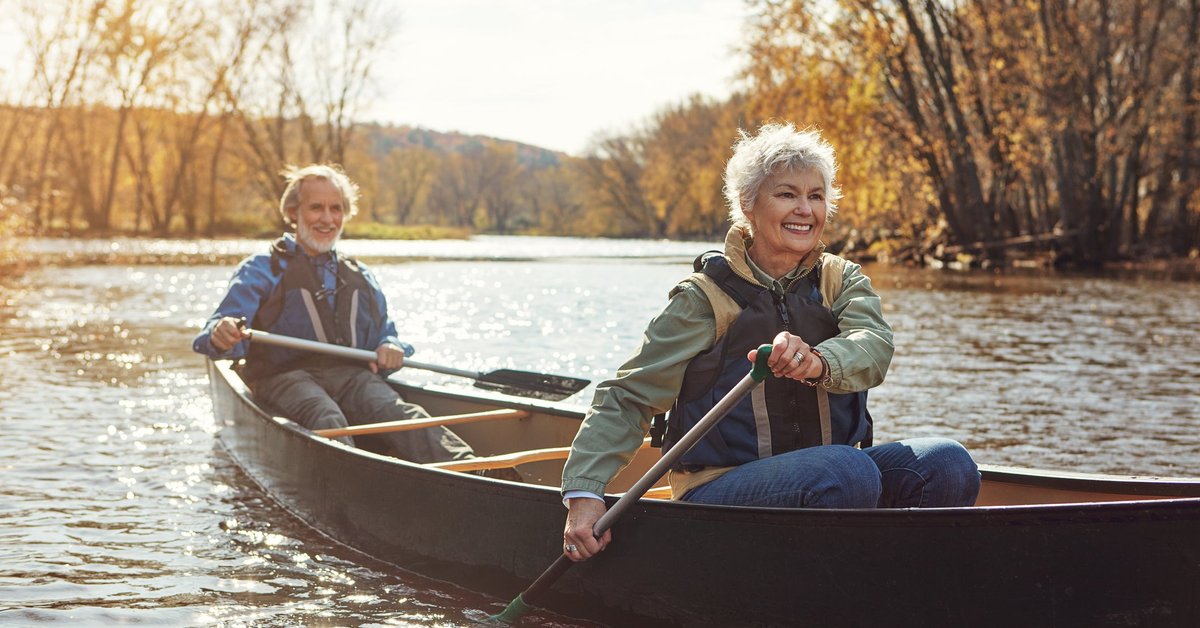 Mature couple rowing together in a canoe.
