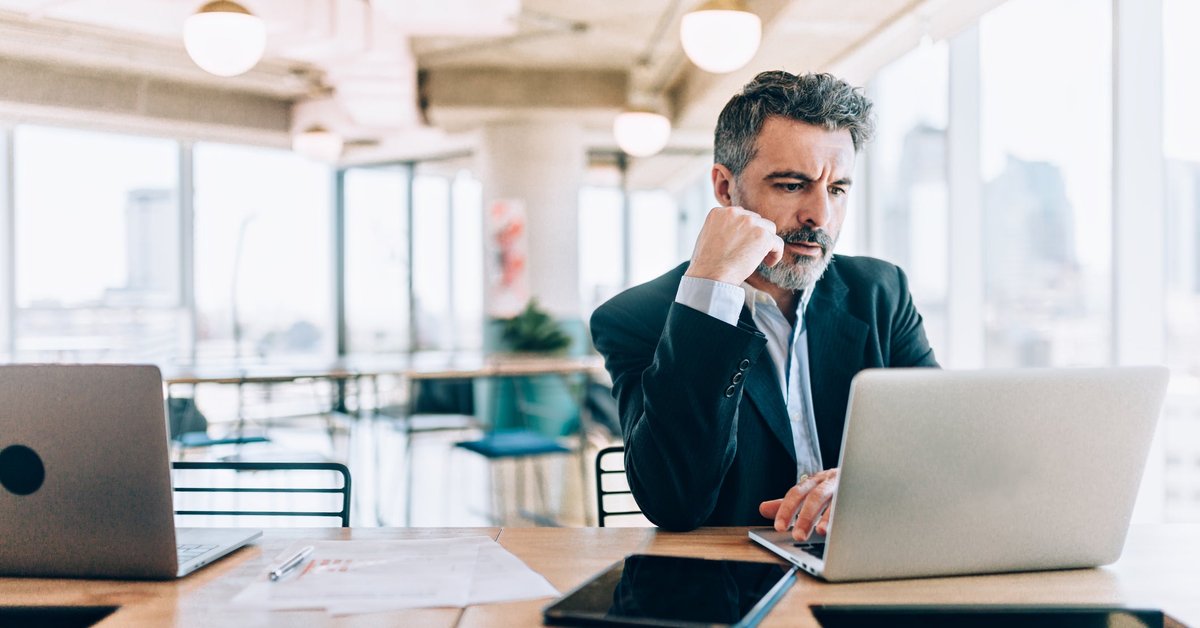 Mature man looking at his laptop with concern on his face.