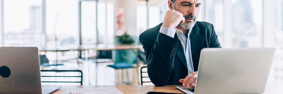 Mature man looking at his laptop with concern on his face.