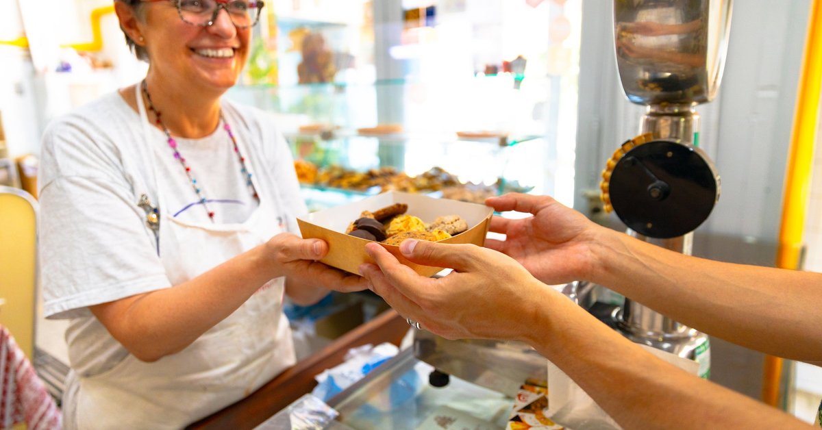 Mature woman selling a box of baked goods
