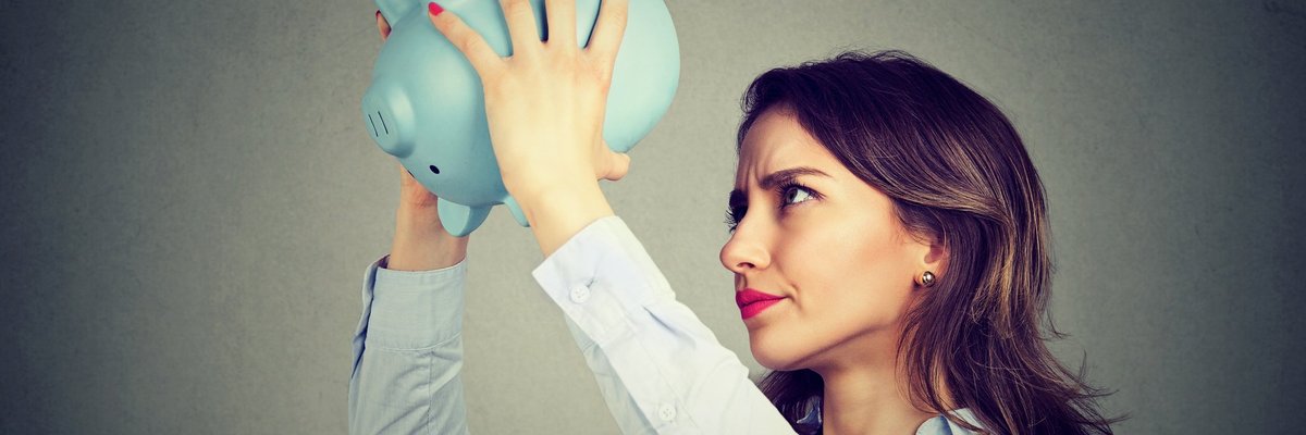 woman holding empty piggy bank upside down