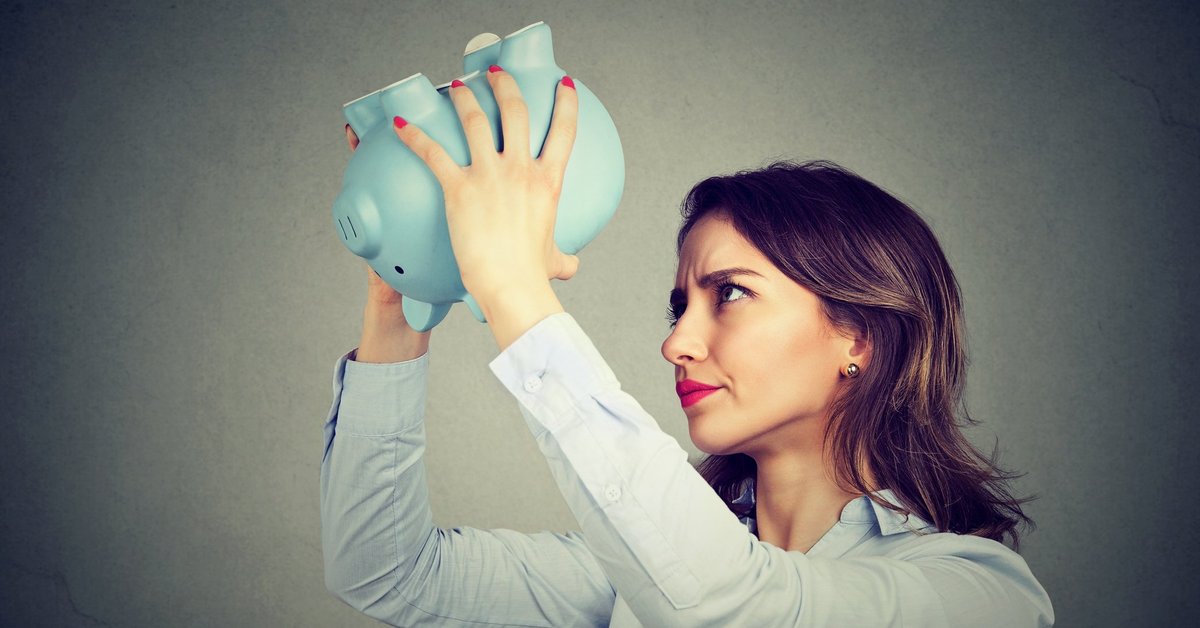 woman holding empty piggy bank upside down