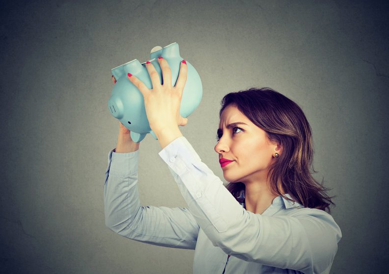 Young Woman Holding Empty Piggy Bank