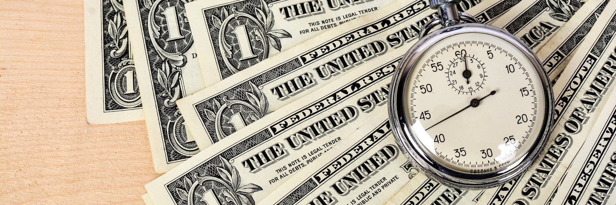 Fanned out one dollar bills with a stop watch on top of them.