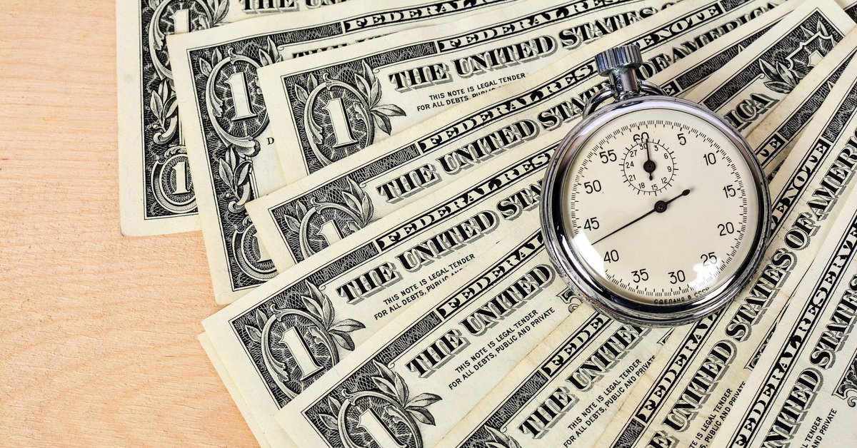 Fanned out one dollar bills with a stop watch on top of them.
