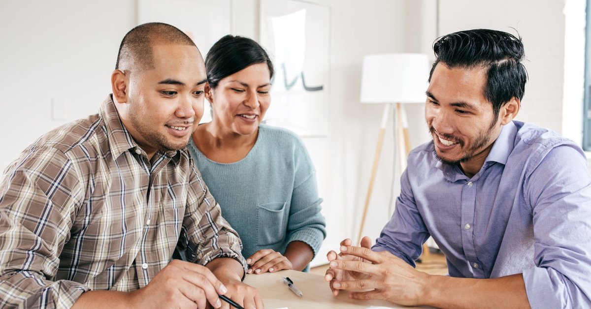Mortgage lender goes over documents with couple.