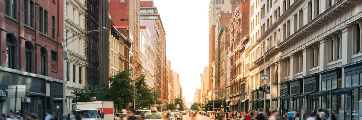 A busy intersection of cars and people in New York City.