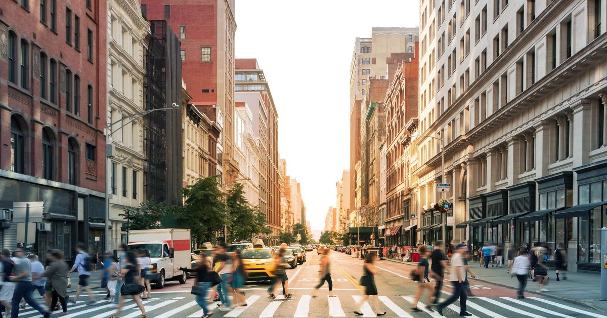 A busy intersection of cars and people in New York City.