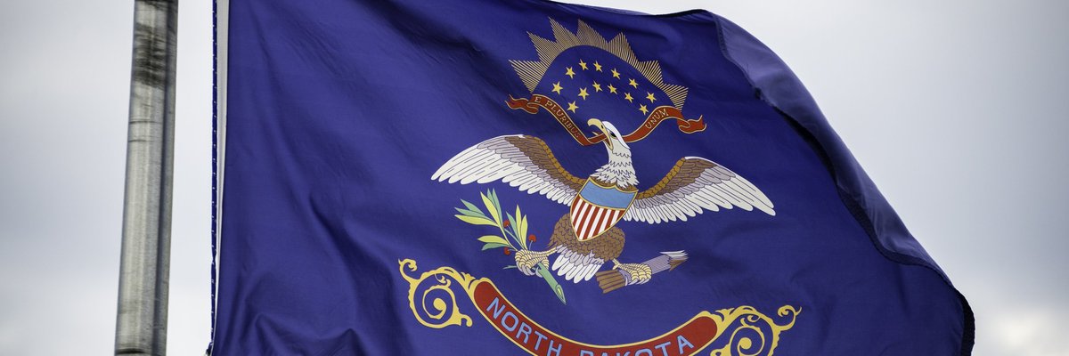 The North Dakota state flag flying on a flagpole.