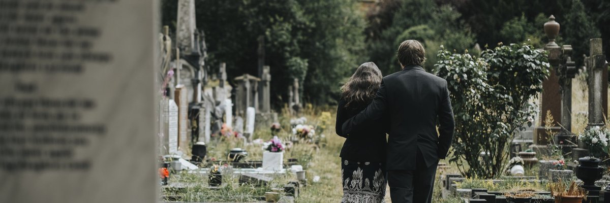 A man and woman attending a funeral.