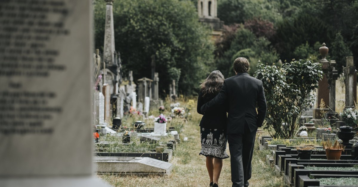 A man and woman attending a funeral.