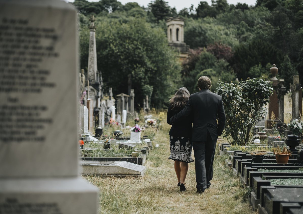 A man and woman attending a funeral.
