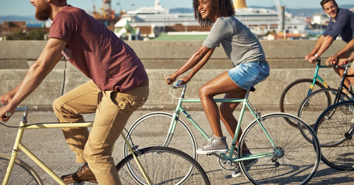 A group of friends riding bikes along the waterfront.