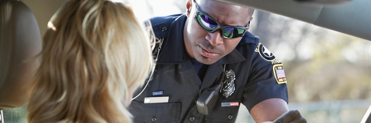 Police officer taking drivers license from woman he has pulled over.