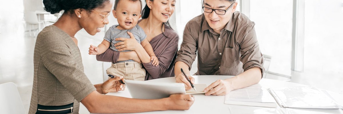 Professional woman reviews paperwork with young family.