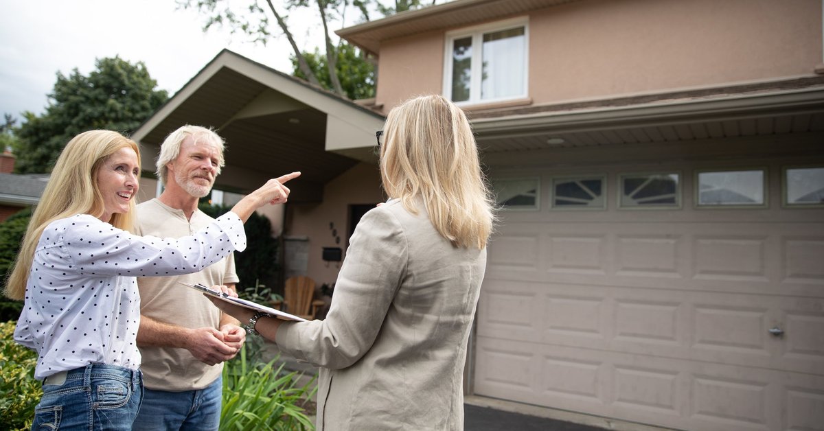 Real estate agent shows mature couple a property.