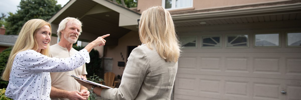 Real estate agent shows mature couple a property.
