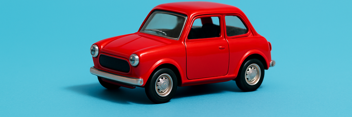 Red toy car on a light blue background.