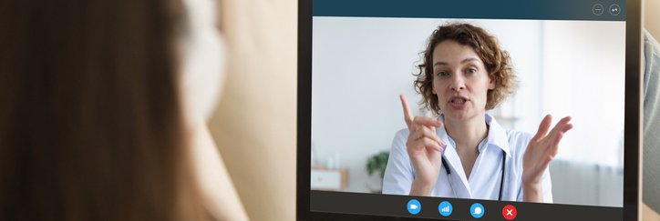 A woman talks to a doctor via her computer
