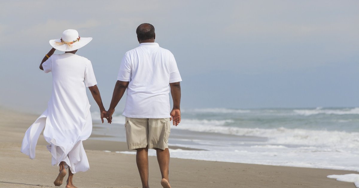 Couple holding hands on the beach. 