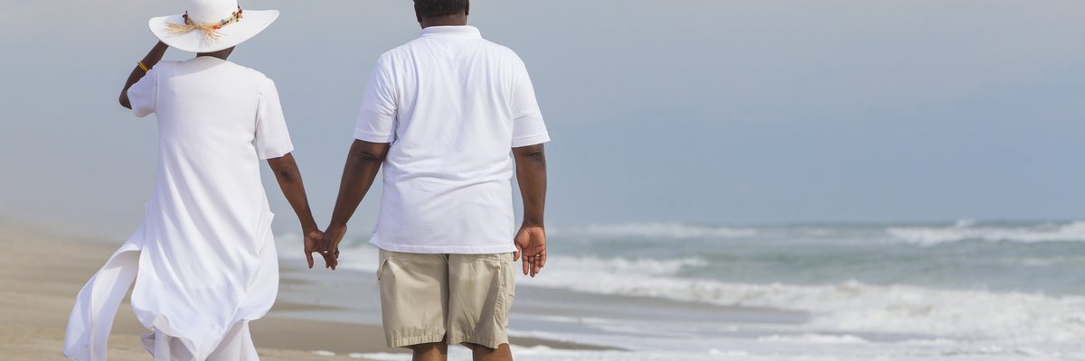 Couple holding hands on the beach. 