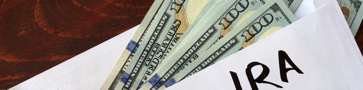 An envelope with Roth IRA written on it and $100 bills falling out.