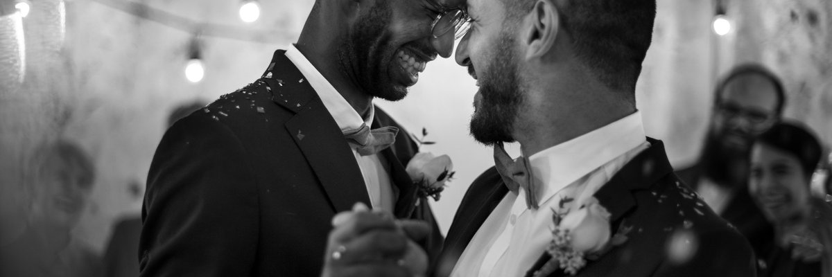 Smiling men dancing at their wedding