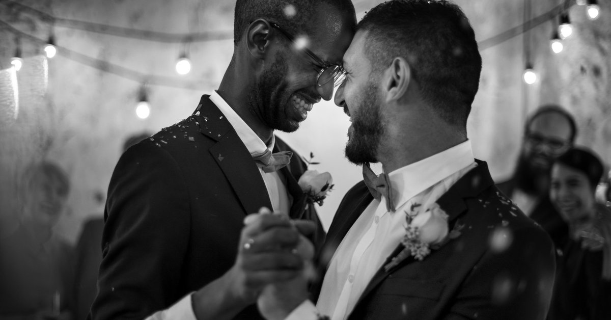 Smiling men dancing at their wedding