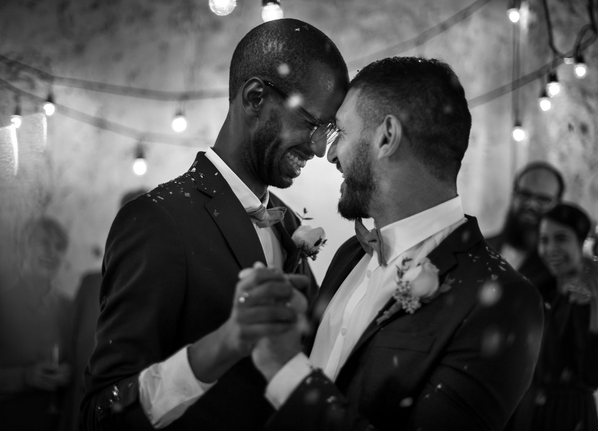 Smiling men dancing at their wedding