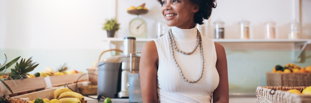  A smiling young woman standing in a cafe.