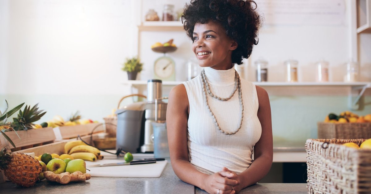  A smiling young woman standing in a cafe.