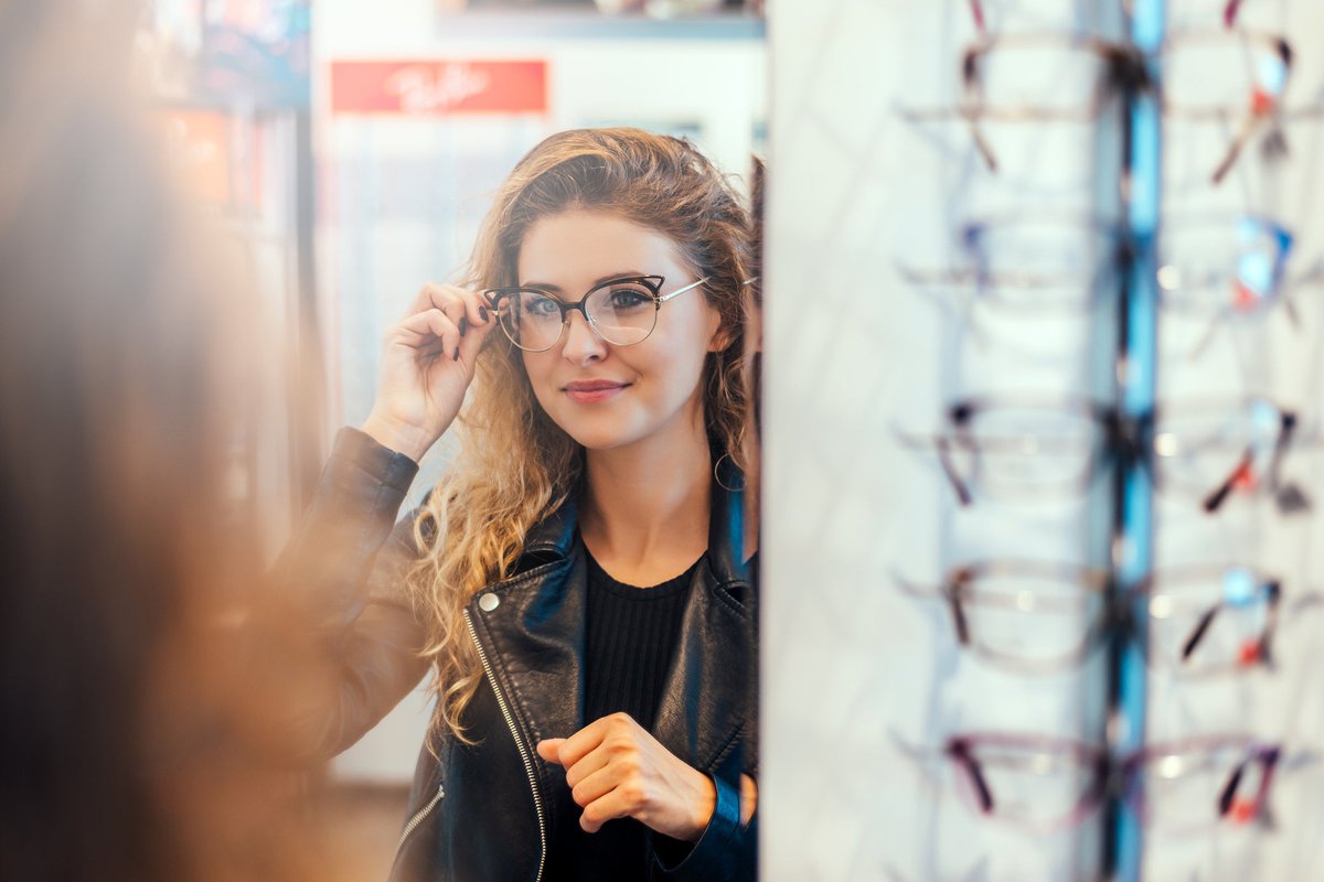 Smiling young woman trying on eyeglasses.